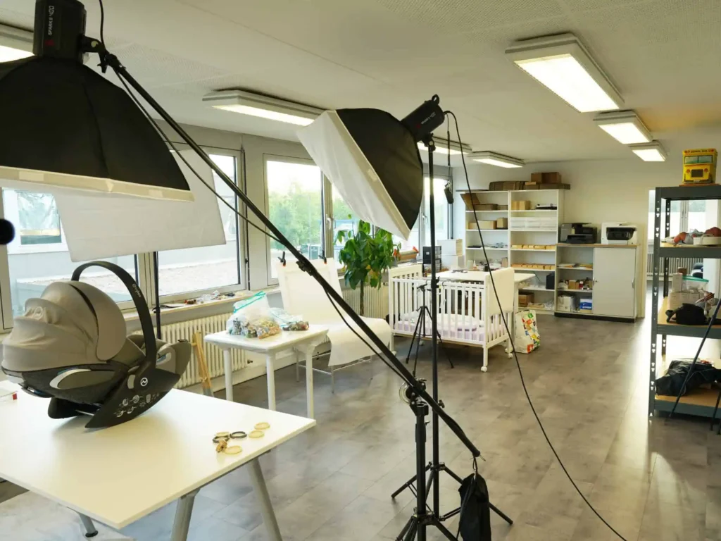 Office with photo studio corner: softboxes, photo table, and product setup.